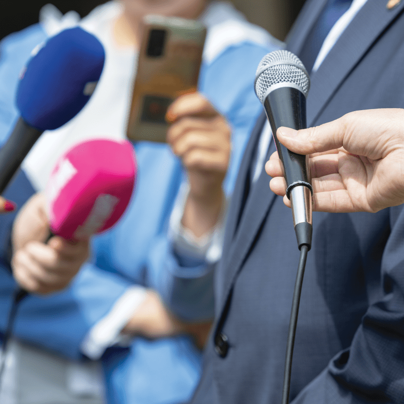 people holding up microphones to person